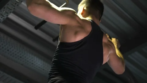 Man with big muscles doing pull-ups on horizontal bar, warm-up and work-out Stock Footage 121803987