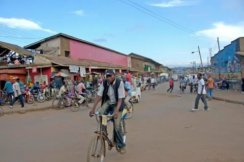 Man biking trough side district of Kampala. Фото