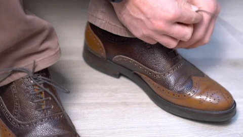 Man binding a shoe, Bridegirl binds his shoes in black and white. a future Vidéo 101613099