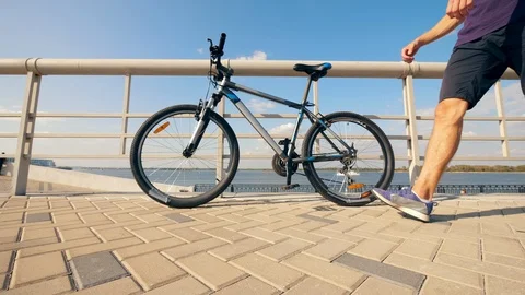 A man with a bionic leg is getting on a bike Stock Footage 116801279