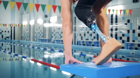 A man with bionic leg jumps into a pool, swimming workout. Stock Footage 105004275