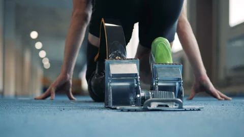 Man with bionic leg prosthesis starts to run on a track, back view. Video stock 100834098