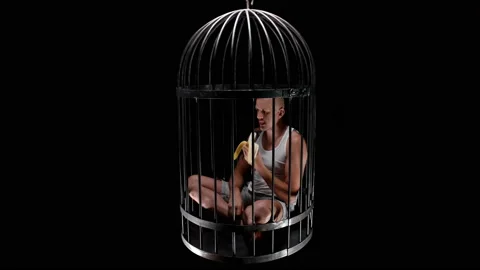A man in a bird cage is in captivity, eats a banana Stock Footage 120122255