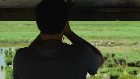 Man in Bird Watching Post Studying Birds with Binoculars Stockbeeldmateriaal 109619435