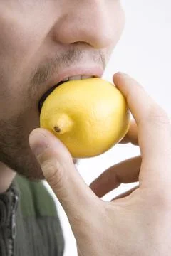 The man bites lemon Stock Photos