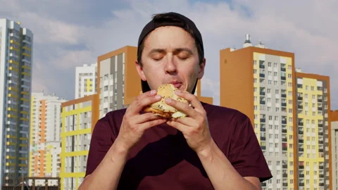 A man biting hamburger with great appetite Stock Footage 201411362
