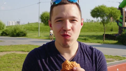 A man biting hamburger with great appetite Stockbeeldmateriaal 220492034