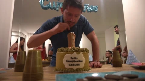 A man biting a penis-shaped cake on his happy birthday surrounded by his male Stock Footage 194502577