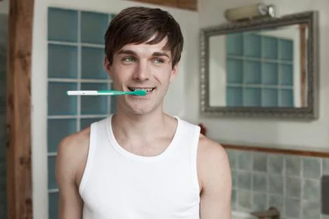 A man biting a toothbrush Stock Photos