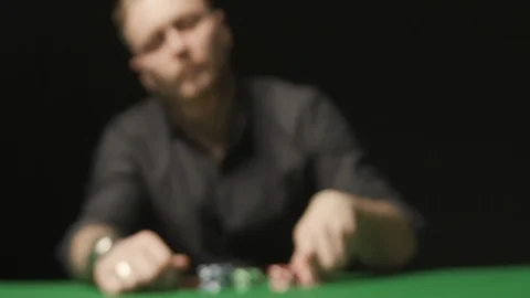 Man on black background doing call with red chips on the green poker table Stock Footage 126515948