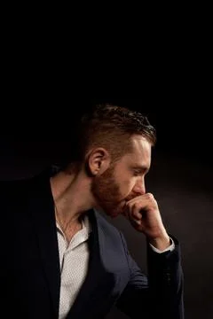 A man on a black background in a jacket and white shirt.Office style. Thinks Stock Photos