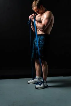 Man on black background keeps dumbbells pumped up in fitness active sexy sport Stock Photos