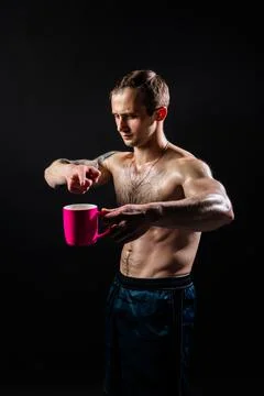 Man on black background keeps dumbbells pumped up in fitness chest sport Stock Photos