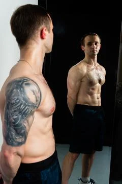 Man on black background keeps dumbbells pumped up in fitness active sexy arm Stock Photos