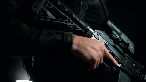 Man on a black background puts the fuse box on the AK into a firing position Stock Footage 144070703