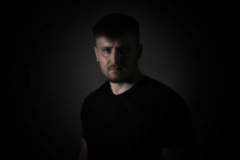 Man on a black background with a serious expression. Stock Photos