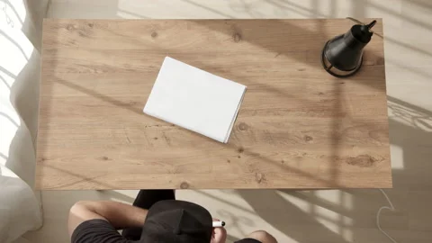Man in black cap sits down at table and write word START on white sheet of A4 Stock Footage 232282019