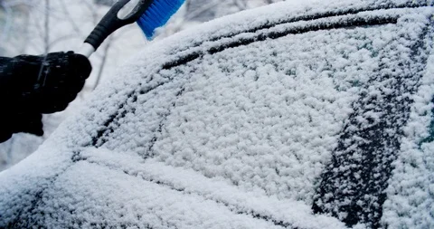 Man in black clothes cleaning black car from the snow. Unrecognizable Man 库存影片 87532001
