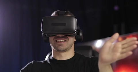 The man in black clothes looks through the VR glasses with headphones using Stock Footage 118694083