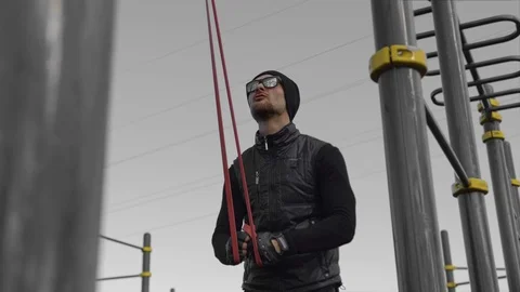 A man in black in cloudy weather plays sports on the site in the city Stock Footage 126852895