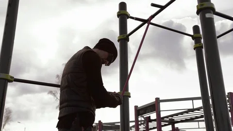 A man in black in cloudy weather plays sports on the site in the city Stock Footage 126852946