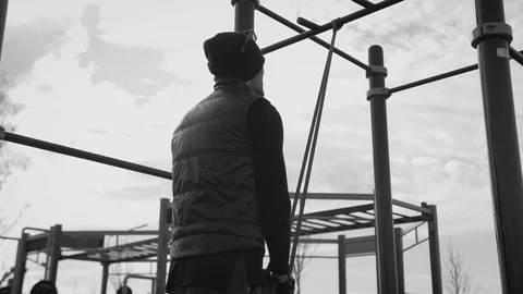 A man in black in cloudy weather plays sports on the site in the city Stock Footage 126951358