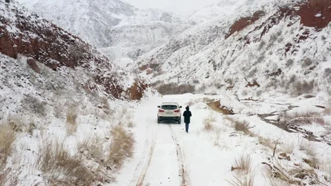 Man in a black coat with a backpack approaches a white car Stock-Footage 269097494