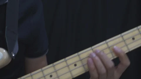 A man in black is dancing with playing an electric guitar bass at home. Stock Footage 127330779