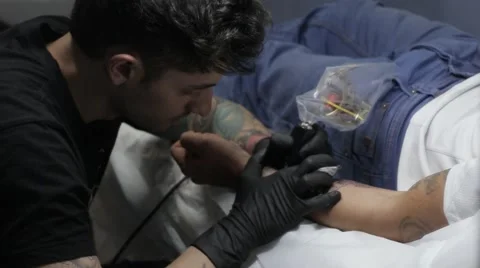 Man with black gloves making a tattoo Stock Footage 61742404
