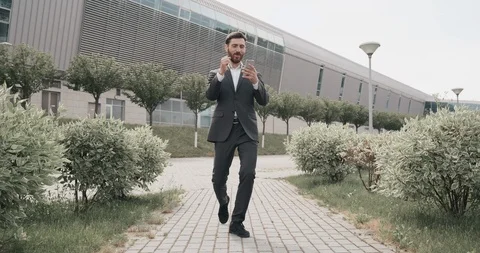 A Man with black Hair and nice Beard dressed in grey Business suit dancing along Stock Footage