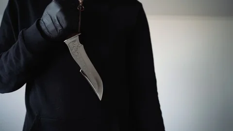 A man in black holds a sharp knife in his hands. Aggressive environment Vidéo 129556136