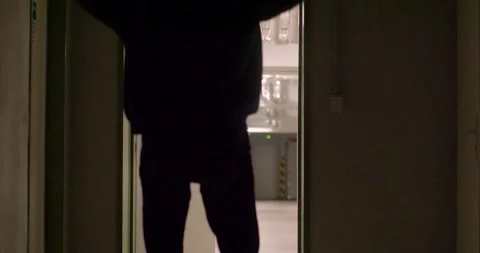 A man in a black jacket explores dimly lit spaces, adding intrigue Stock Footage 311816823
