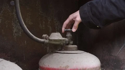 A man in a black jacket raises his hand and checks the valve on an old, Stock Footage 219415794