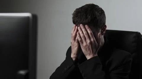 Man in a black jacket stressed at computer desk feeling overworked and exhausted Stock Footage 318442481