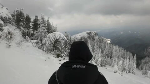 Man In A Black  Jacket  Walking On Snow-Covered Mountain Stock Footage 150958216