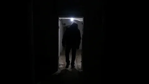 Man in a black jacket walks down a long dark tunnel Stock-Footage 124408400