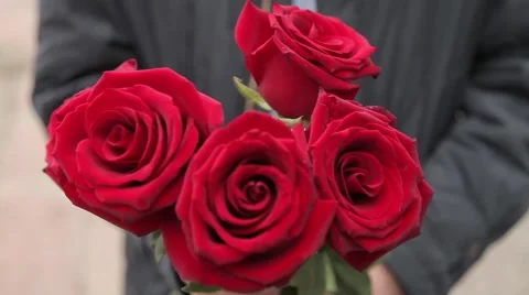 Man in black keeps five red roses Stock Footage 64290682