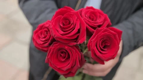 Man in black keeps five red roses 動画素材 64290718