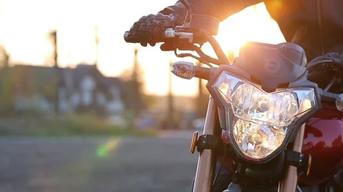 Man in black leather jacket and white helmet sits on motorcycle turns on lights Stock Footage 81493502