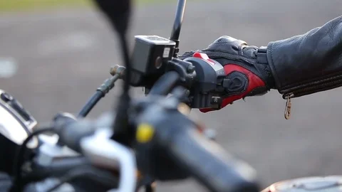 Man in black leather jacket and protective gloves powers engine Stock Footage 81493556