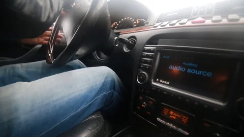 A man in a black leather jacket drives a car. Control panel of car Stock Footage 128122568
