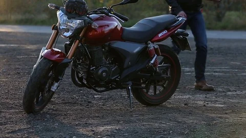 Man in black leather jacket goes to his motorcycle and sits on it Stock Footage 81492986