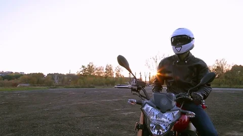 Man in black leather jacket on motorcycle turns on lights before journey Video stock 81492816