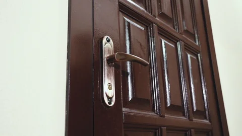 A man in a black leather jacket opens the door with a key and enters inside Stock Footage 111754977