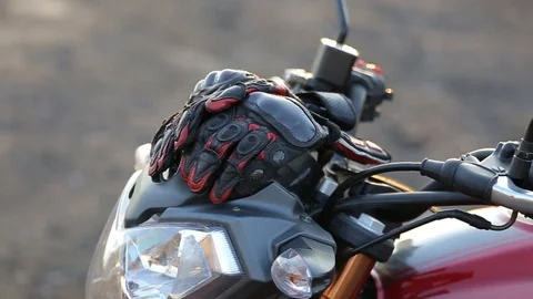 Man in black leather jacket sits on motorcycle puts on protective gloves Stock Footage 81493378