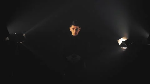 Man in black in light rays and smoke Stock Footage 132837455