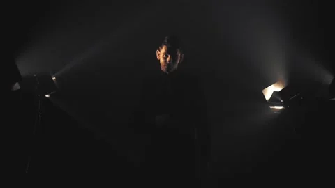 Man in black in light rays and smoke Stock Footage 132837681