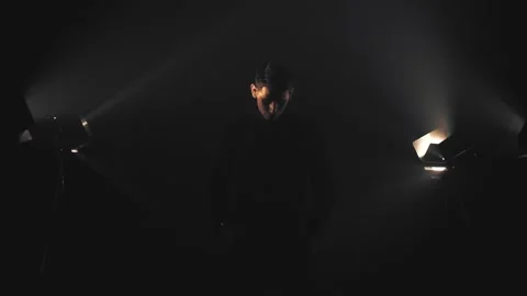 Man in black in light rays and smoke Stock Footage 132837757