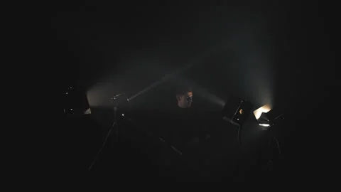 Man in black in light rays and smoke Stock Footage 133241379