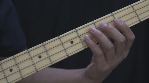 A man in black is practicing a C major scale on the guitar bass at home. Stock Footage 127330826